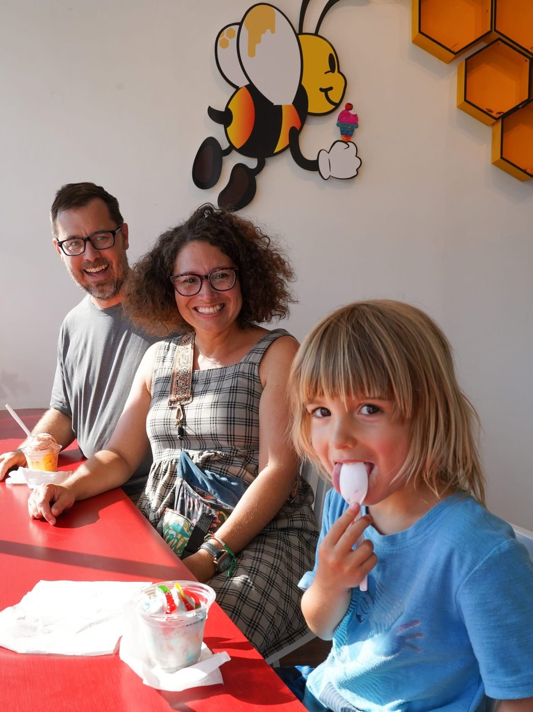 Guests at a table beneath the big bee mural at The Bee