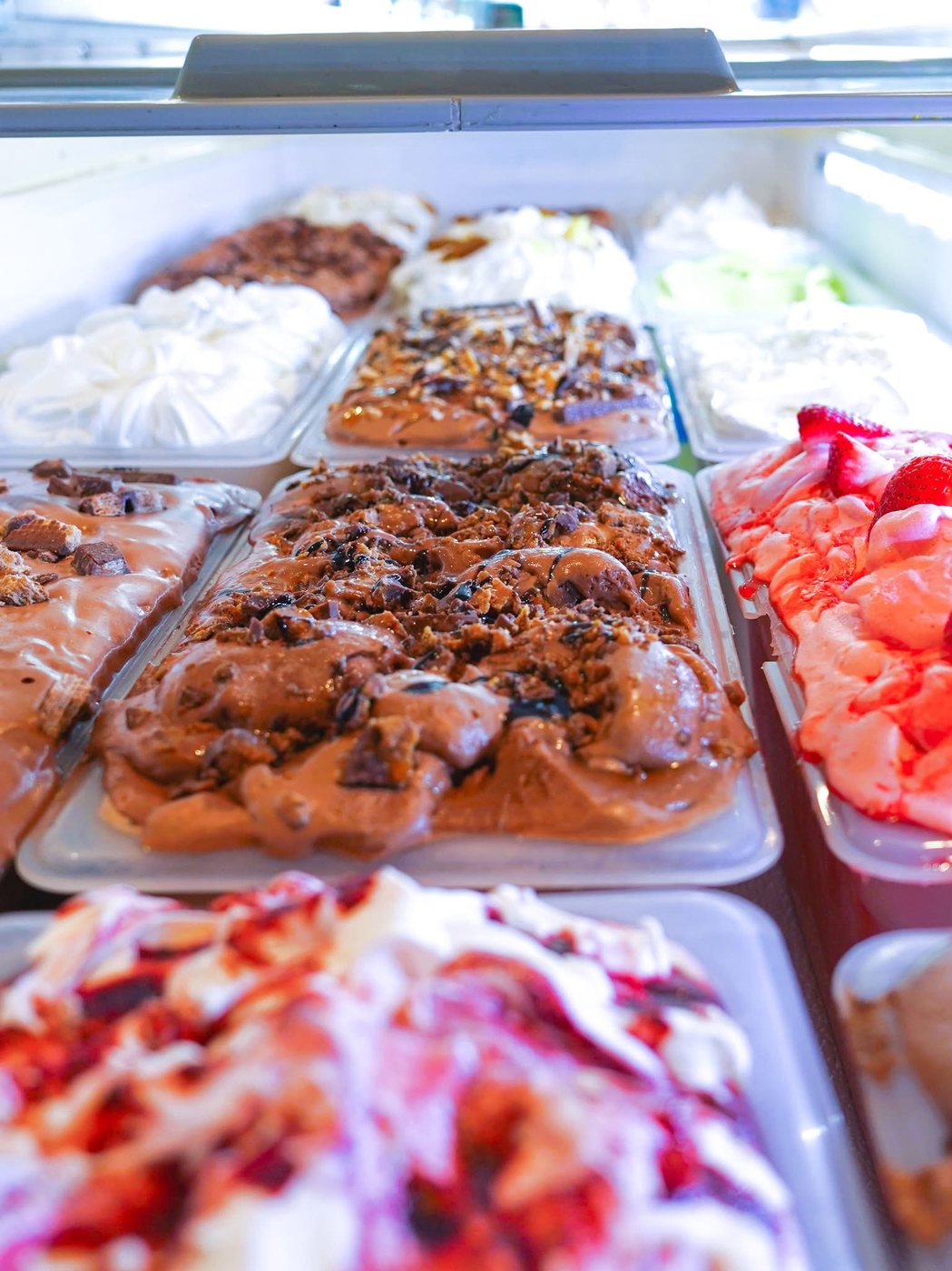 Rows of fresh ice cream flavors in the case at The Bee Ice Cream