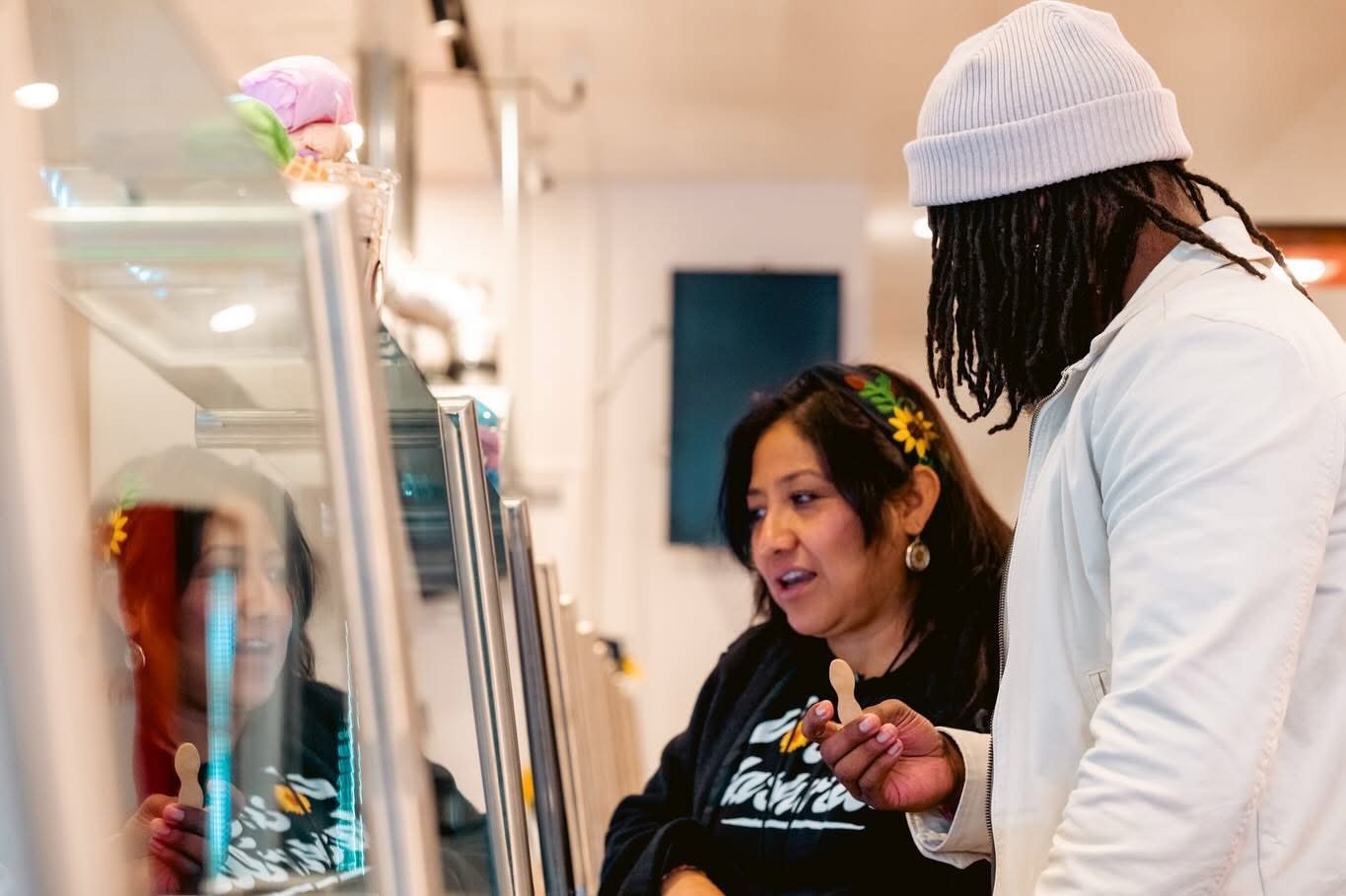 Two customers choosing flavors at the case